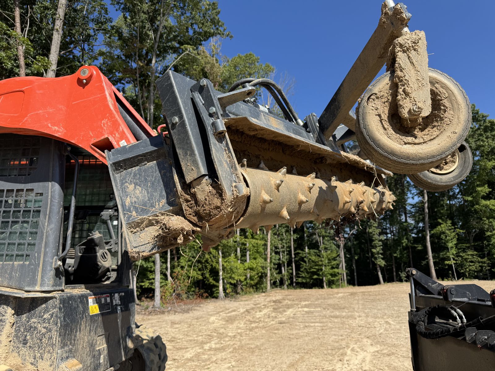 Hydraulic power rake attachment on the SVL97-2 loader arms